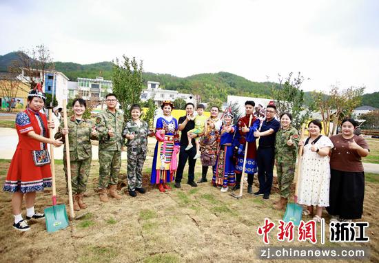 各族群众栽种石榴树后合影。梅城镇供图