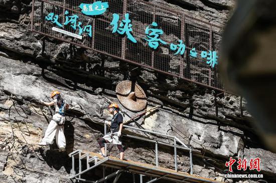 10月11日，游客在贵州省遵义市绥阳县双河洞景区“悬崖之上·侠客咖啡”项目挑战中。中新社记者 瞿宏伦 摄