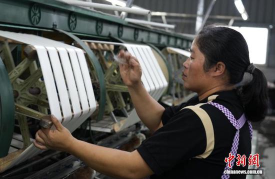 图为10月16日，工人在车间里进行复摇(返丝)工作。石小杰 摄