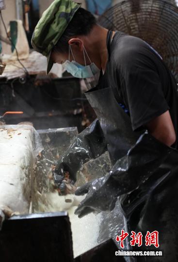 图为10月16日，工人在车间里进行“打棉”工作。石小杰 摄