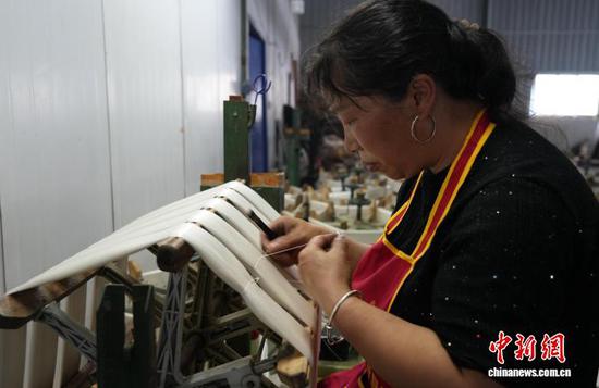 图为10月16日，工人在车间里进行编丝工作。石小杰 摄