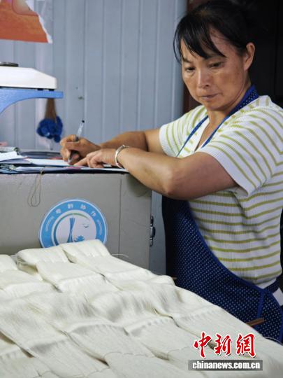 图为10月16日，工人正在为处理好的蚕丝称重。石小杰 摄