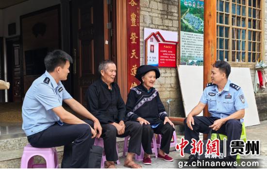 图为杨仕荣与民警在山村走访。 赵佳玲 摄 图为杨仕荣与民警在山村走访。 赵佳玲 摄