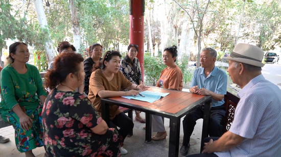 宋爱娟与居民共同学习铸牢中华民族共同体意识相关内容。融媒体中心记者 王一川摄