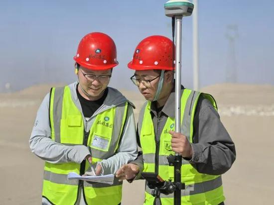 工作人员正进行道路路基放线和土地平整度测量。(张淑华 摄)
