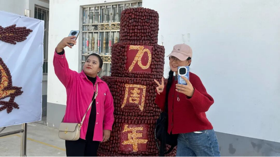游客在红枣元素打卡点打卡笑开颜。