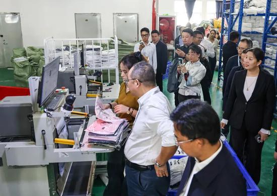 10月19日,2025民营企业助力南疆发展推进会参会代表在新疆纱纤亿公司考察。记者 许晓龙 摄