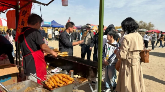 沙岸美食摊腾香,游人熙攘穿梭尝味忙。