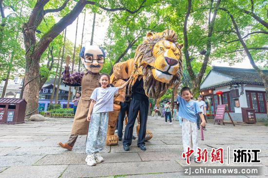 :
10月17日,浙江湖州南浔古镇,巡游表演者与游客进行互动。屠旭东 摄