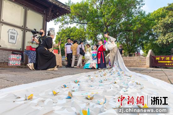 10月18日,浙江湖州南浔古镇,巡游扮演者与游客进行互动合影。屠旭东 摄