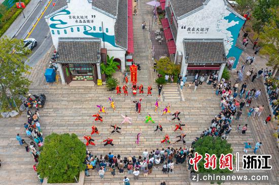 图为10月19日,浙江湖州南浔古镇,来自广东普宁南山英歌队的英歌《雄风》表演,吸引游客围观。(无人机照片)屠旭东 摄 图为10月19日,浙江湖州南浔古镇,来自广东普宁南山英歌队的英歌《雄风》表演,吸引游客围观。(无人机照片)屠旭东 摄