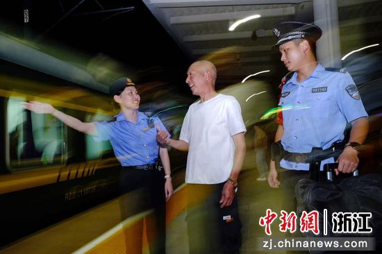 图为:铁路民警在站台上为旅客服务。中新社发 贺瑞明 摄