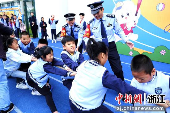 图为:铁路民警在学生拔河比赛中进行互动和加油。中新社发 贺瑞明 摄