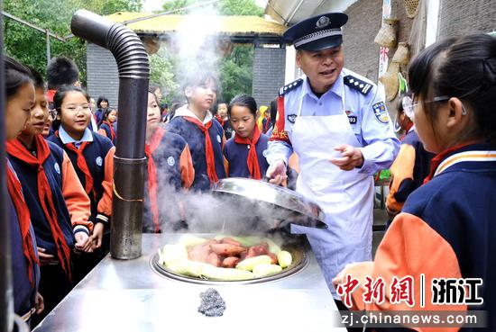 图为:铁路民警化身厨师和学生们互动。中新社发 贺瑞明 摄