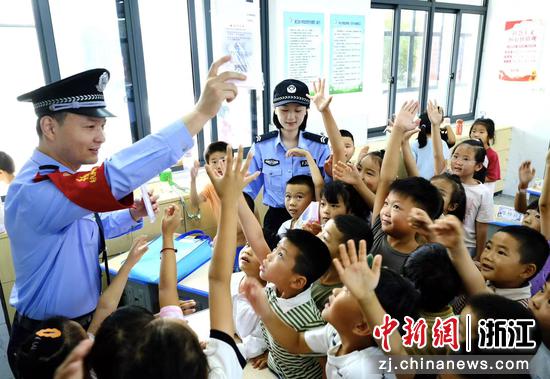 图为:铁路民警和小朋友互动。中新社发 贺瑞明 摄