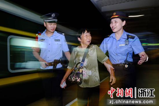 图为:铁路民警在站台上为旅客服务。中新社发 贺瑞明 摄