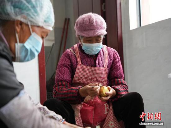 图为老人在贵州省毕节市赫章县金银山街道的“岁月食堂”厨房免费帮忙削土豆。中新网记者 周燕玲 摄 图为老人在贵州省毕节市赫章县金银山街道的“岁月食堂”厨房免费帮忙削土豆。中新网记者 周燕玲 摄