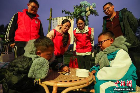 10月24日晚，孩童在诗意田园·游园竞趣场景中体验“斗棋”。 记者 瞿宏伦 摄