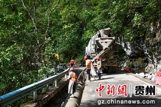 工人在罗甸县龙坪镇大关村段用混凝土填埋管网。潘希来 摄