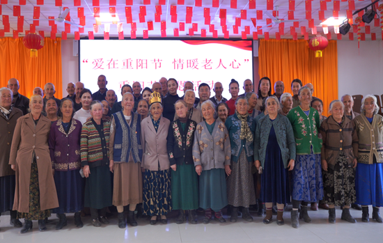 村“两委”、驻村工作队员与村内老年人合影。