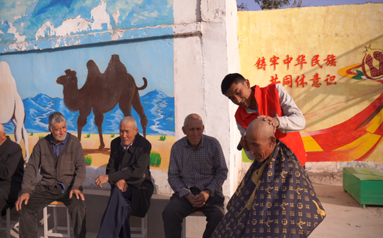 志愿者为老年人提供“爱心义剪”服务。