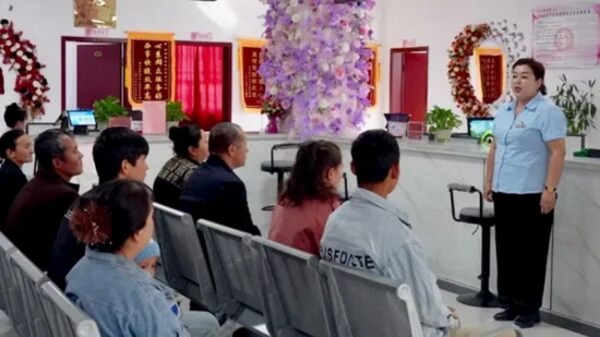 工作人员向群众宣讲政务服务政策。