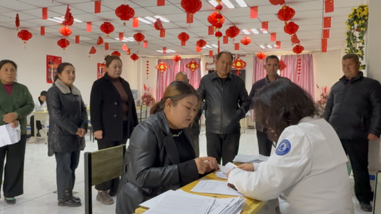 工作人员在核对领取康复辅助器对象的信息。