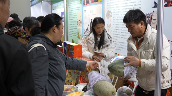 北京市民在交易会上选购安迪尔甜瓜。阿的拉 摄