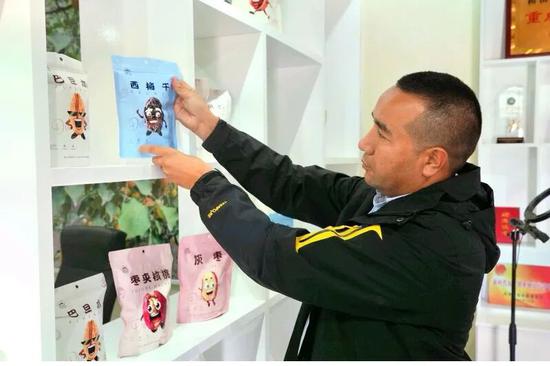 阿力木江正在往货架上摆货。（资料图）