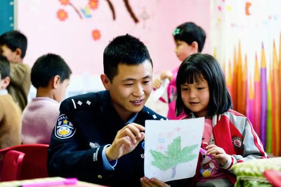 张仕征在教辖区孩子画画。