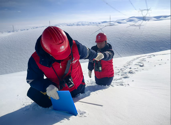 新疆送变电公司员工蹚雪巡视750千伏伊库线。马赟广 摄 新疆送变电公司员工蹚雪巡视750千伏伊库线。马赟广 摄