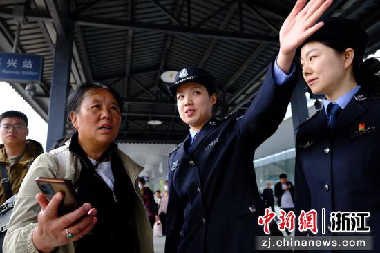 图为：嘉兴站派出所民警在站台为旅客指引换乘方向。中新社发 贺瑞明 摄