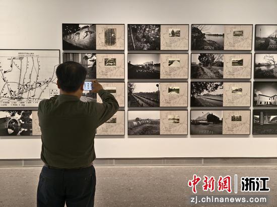 图为：参观者拍摄展出的摄影作品。中新社发 浙江省摄协 供图