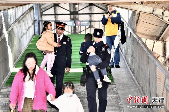 图为“津旅时光号”列车乘警帮助孩子上车,热心服务旅客。(北京铁路公安局天津公安处供图) 图为“津旅时光号”列车乘警帮助孩子上车,热心服务旅客。(北京铁路公安局天津公安处供图)