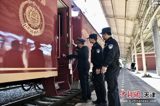 图为“津旅时光号”乘警在列车开车前会同列车工作人员检查车体,确保列车平安行驶。(北京铁路公安局供图) 图为“津旅时光号”乘警在列车开车前会同列车工作人员检查车体,确保列车平安行驶。(北京铁路公安局供图)
