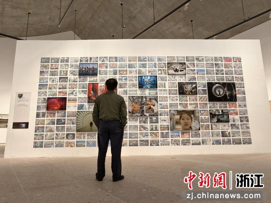 图为：参观者驻足观看展出作品。中新社发 浙江省摄协 供图