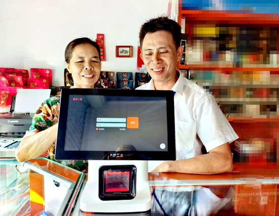 图为客户经理指导老年零售户使用云POS。 滕君 摄