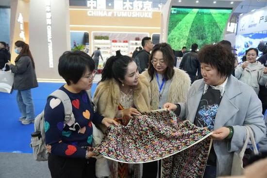 游客选购“五星出东方利中国”文创元素丝巾。阿卜力克木·依卜拉依木 摄