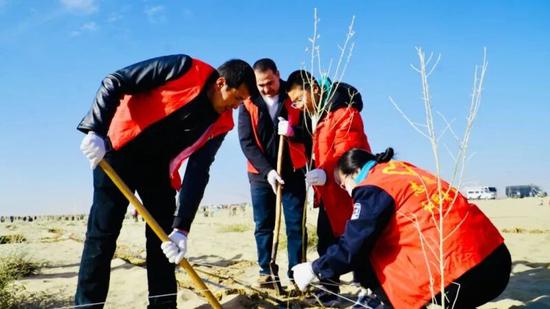 干部群众在植树点义务植树。