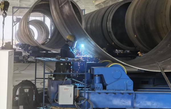 11月13日,新疆宏泰重工有限公司年产300套风机塔筒工厂项目的工作人员正在对单结筒进行组对焊接。苏波 摄 11月13日,新疆宏泰重工有限公司年产300套风机塔筒工厂项目的工作人员正在对单结筒进行组对焊接。苏波 摄