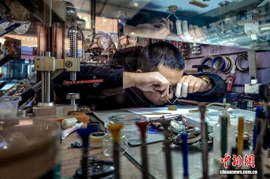 11月16日,在天津市河北区王串场街“修补巷”, 修表匠王晴川为顾客维修手表。中新社记者 佟郁 摄 11月16日,在天津市河北区王串场街“修补巷”, 修表匠王晴川为顾客维修手表。中新社记者 佟郁 摄