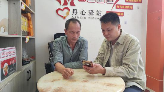 图为“数字辅导员”上门指导老年零售户使用智能手机订购卷烟。张芳 摄 图为“数字辅导员”上门指导老年零售户使用智能手机订购卷烟。张芳 摄