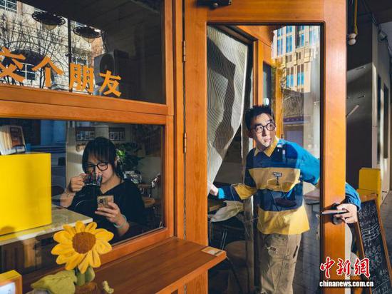 11月19日，“00后”董怡彤（左）在三七开咖啡酒馆喝着香橙肉桂红酒。　中新社记者 佟郁 摄