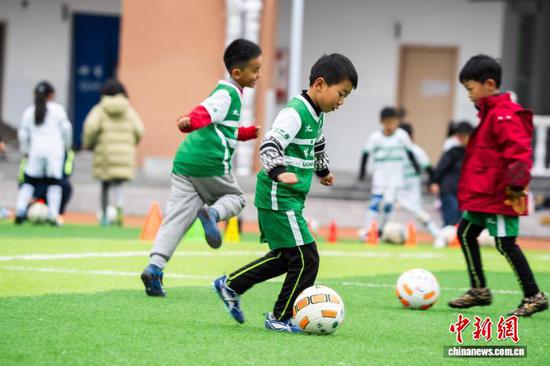 2025年11月22日，在贵州省毕节市实验学校足球场上，孩子们在老师的指导下学习足球 。罗大富 摄