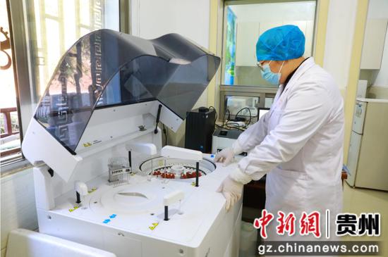 检验技师正在调试生化分析仪。谢达意 摄