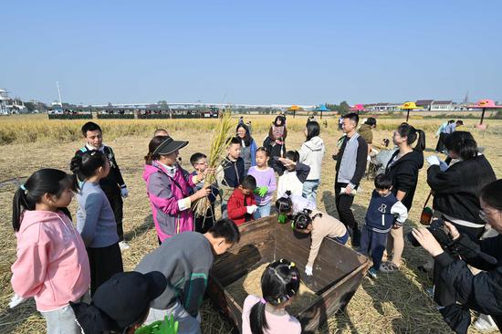 亲子家庭听取割稻的要点讲解