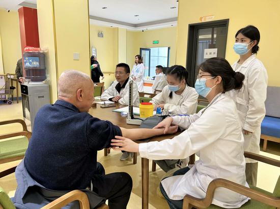 医护人员给老人做血压监测。罗金 摄