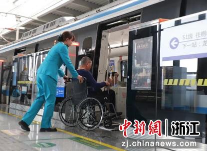 车站工作人员帮助乘坐轮椅的乘客。 浙江幸福轨道公司 供图 车站工作人员帮助乘坐轮椅的乘客。 浙江幸福轨道公司 供图
