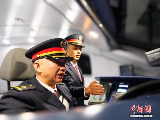 图为担任贵州盘兴高铁首发列车司机的王昌利和陈鑫在驾驶舱内。郑蔚 摄 图为担任贵州盘兴高铁首发列车司机的王昌利和陈鑫在驾驶舱内。郑蔚 摄