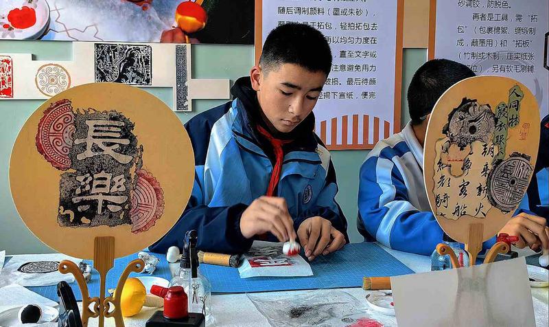 11 月 25 日，在昌吉州第四中学非遗展厅，同学们正在学习拓印。移志向摄